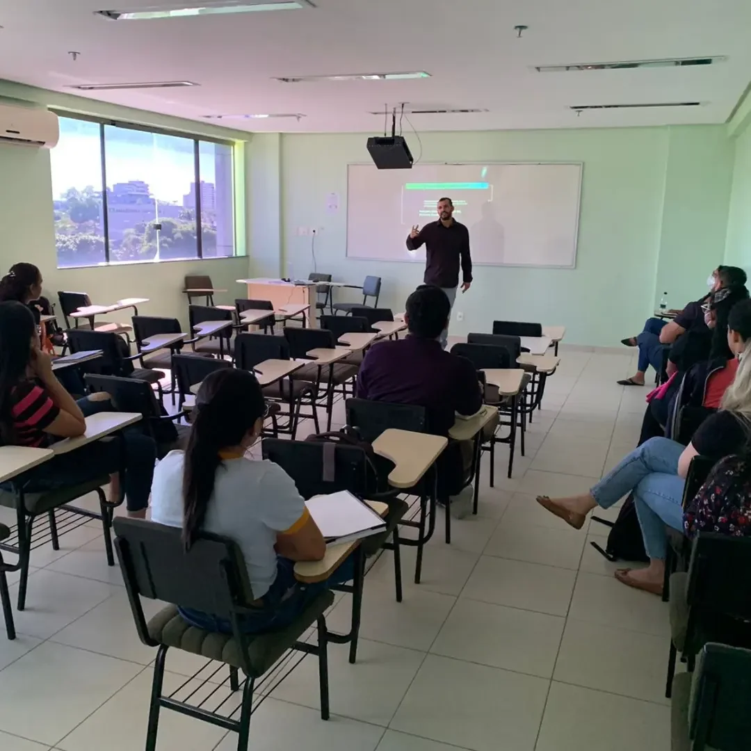 Allan Felipe ministrando uma aula presencial, com participantes acompanhando em notebooks
